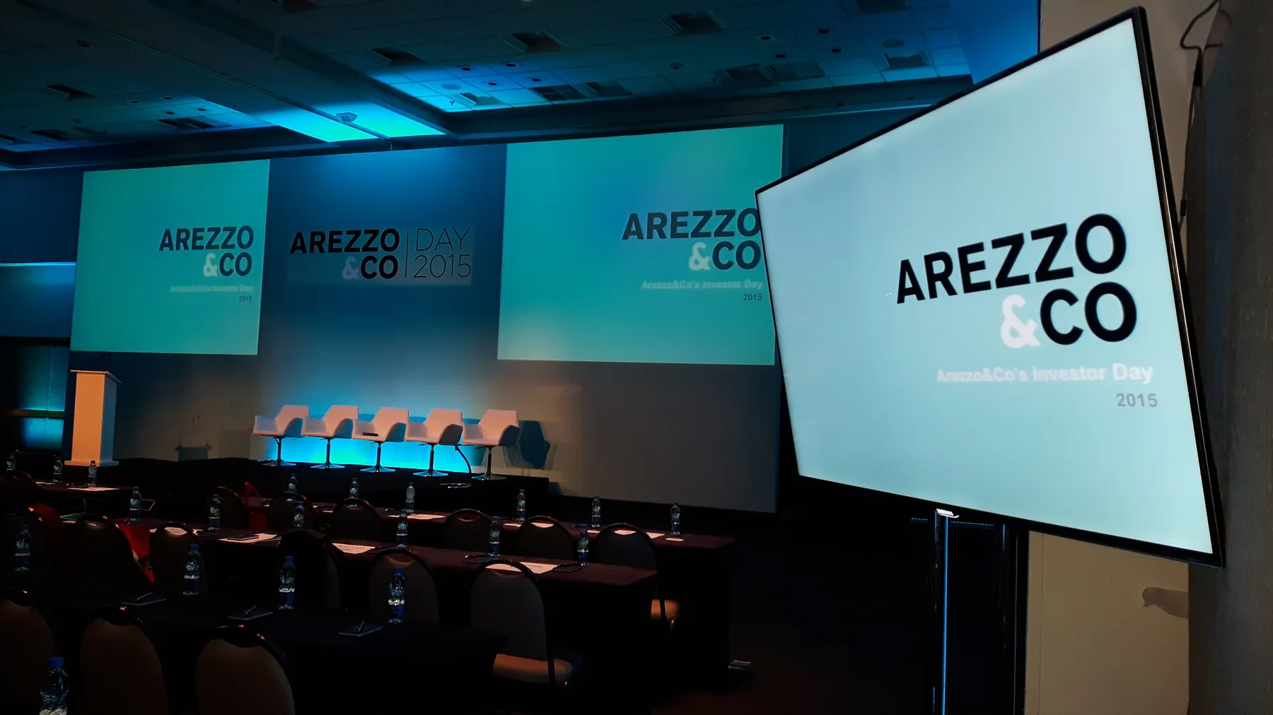 Auditório Arezzo e Co com telões e palco iluminado em azul