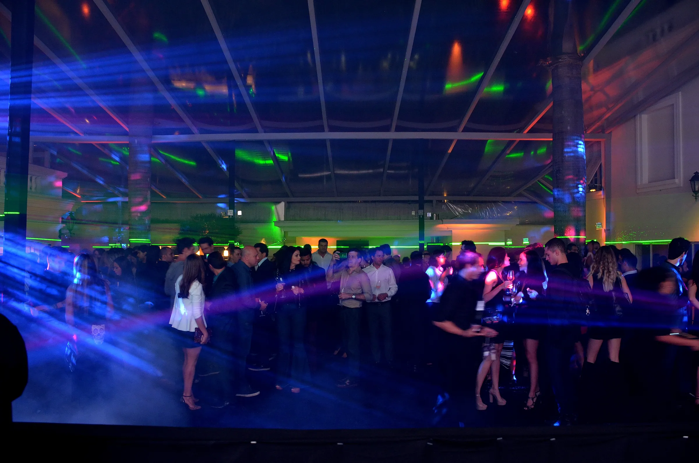 Pista de dança com feixes de laser sobre os convidados