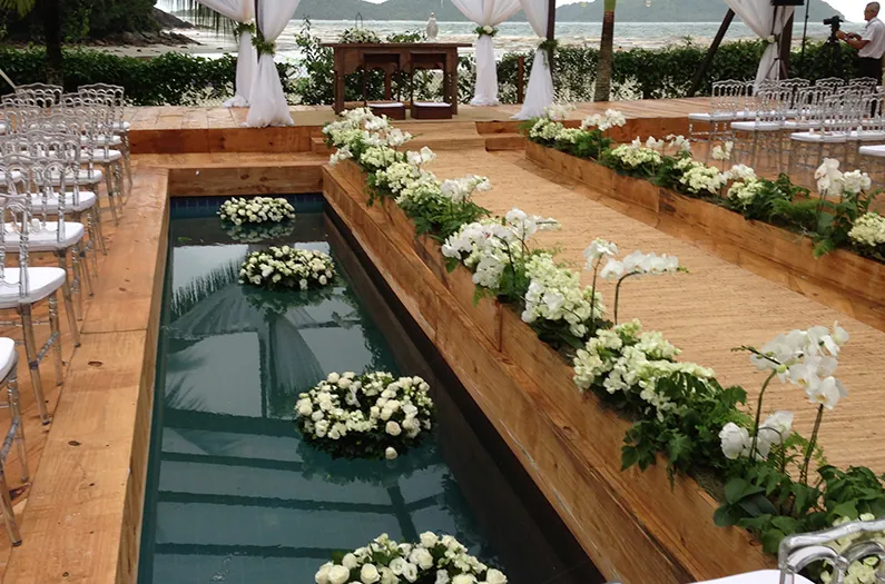 Cerimônia ao ar livre com espelho d'água e flores brancas