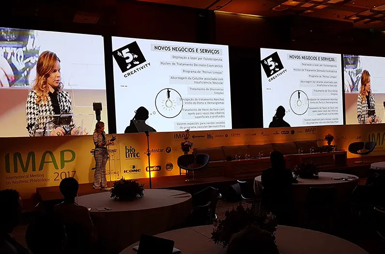 Palestrante no palco diante de telões