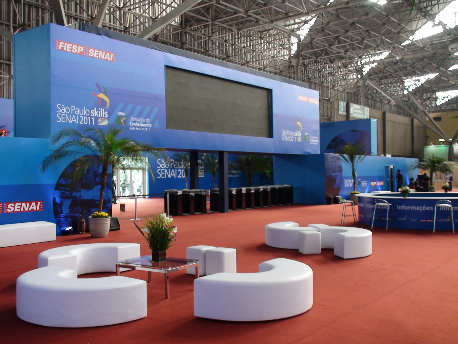 O mesmo espaço montado no pavilhão, com estrutura azul FIESP SENAI e lounges brancos